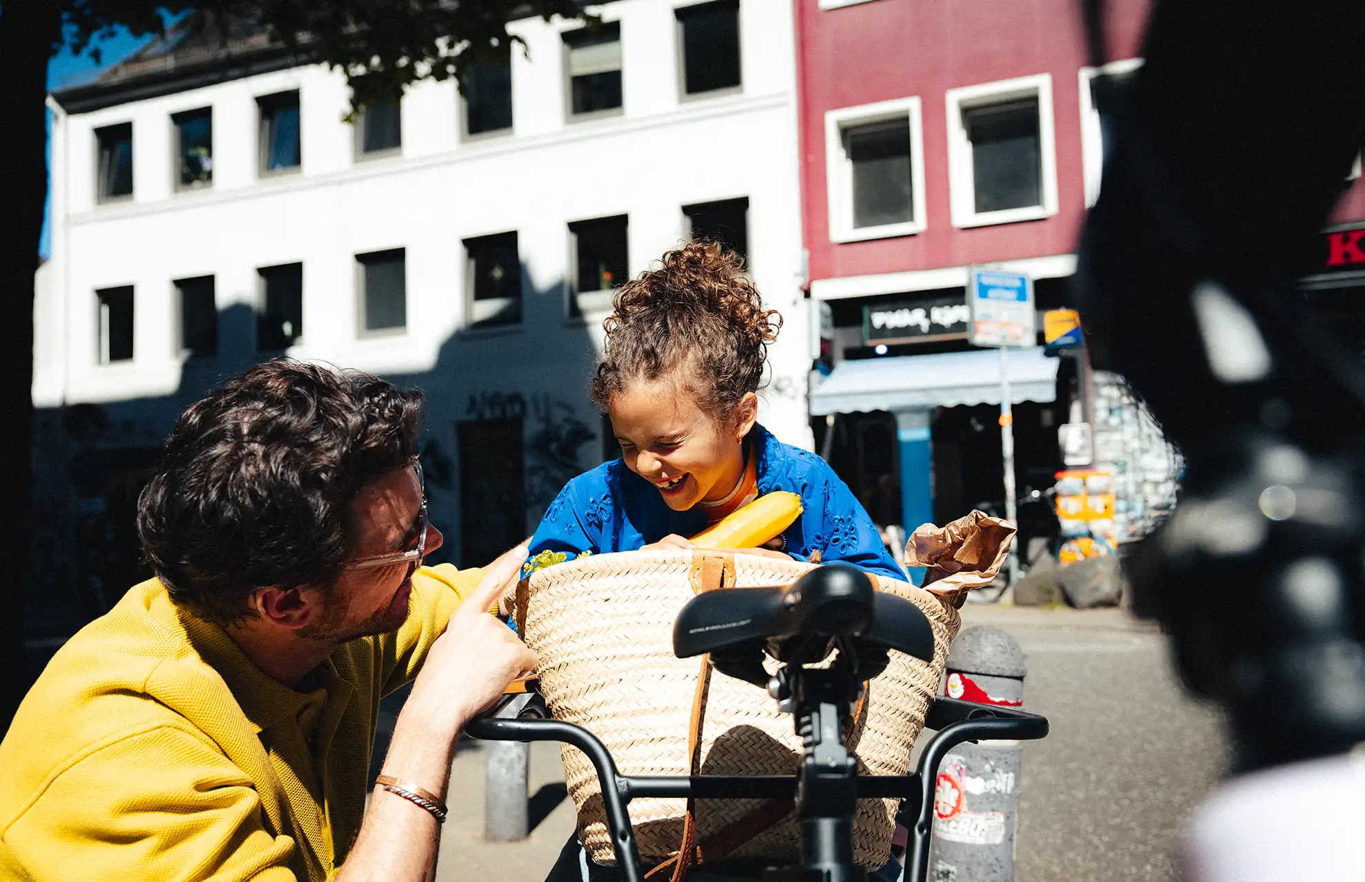 Vater mit Tochter und vollgepacktem Lastenrad